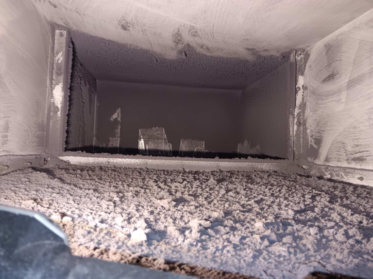 Dried overspray residue built up inside a paint booth exhaust plenum